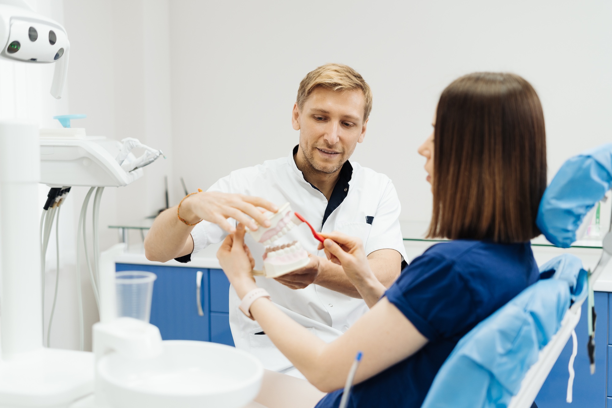 Dentist showing the correct dental hygiene on white background Dentist showing the correct dental hygiene on white background
